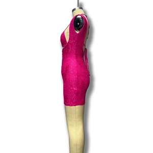 Détail macro de la dentelle au crochet magenta et découpe latérale sur la robe slim
