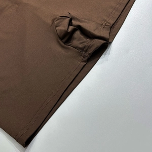 Détail du tissu extensible marron foncé avec coutures renforcées et finition plate de qualité