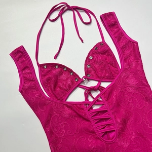Détail d'un body en dentelle rose rouge avec attaches licou et laçage à œillets