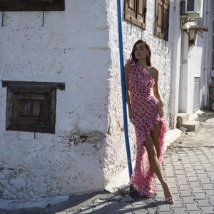 Detail of floral pink asymmetric chiffon dress with ruffled one shoulder and high-low hemline