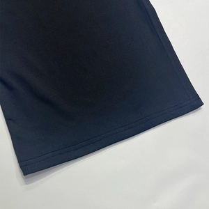Close-up of high-density black knit fabric showing clean double-needle hem stitching
