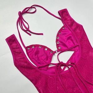 Détail d'une robe en dentelle fuchsia avec dos nu, œillets argentés et lacets