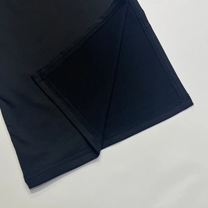 Detail view of the side slit design and stitching on black knitted fabric top