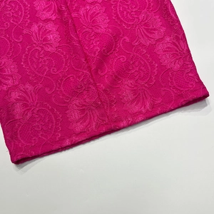 Macro de dentelle fuchsia avec motifs floraux complexes et détails ajourés précis