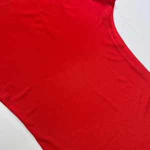 Detailed macro view of the red knit fabric and high-quality double-needle stitching on the U-neck