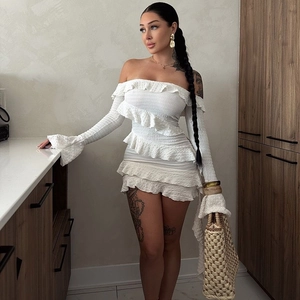 Détail d'une mini robe blanche à épaules dénudées avec tissu plissé et bords à volants