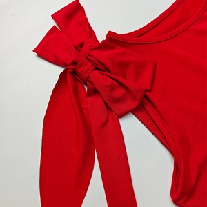 Dettaglio del grande fiocco rosso sulla spalla di questo elegante top estivo da donna