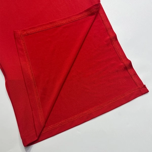 Macro shot of precise stitching and high-quality red knit fabric on the hem of a slim top