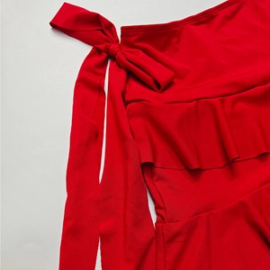 Dettaglio del set in maglia rossa con grande fiocco e volant a strati di tendenza