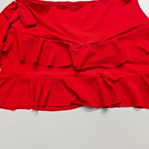 Dettaglio mini gonna rossa a balze con fiocco laterale e design in tessuto a strati