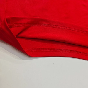 Dettaglio del tessuto a maglia rosso con cuciture a doppio ago di qualità sull'orlo