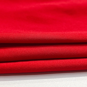 Dettaglio ravvicinato della trama in maglia rossa con focus su cuciture e qualità del tessuto