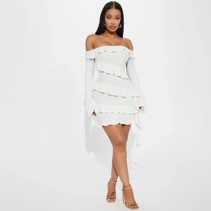 Gros plan d'une mini robe blanche à épaules dénudées avec volants et manches évasées