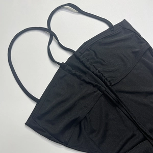 Détail de la poitrine froncée et des fines bretelles de la robe noire dos nu licou