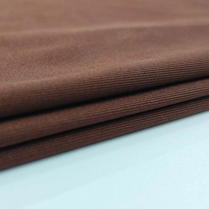Detail of brown ribbed knit fabric showing the soft texture and fine vertical thread patterns