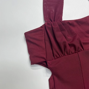 Detail of burgundy mesh dress showing intricate pleated texture and material stitching