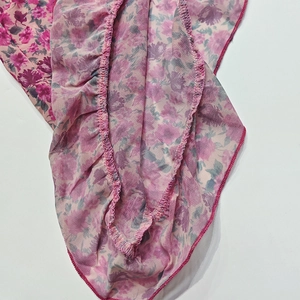 Close-up of floral chiffon fabric with delicate ruffle edges and precise stitching detail