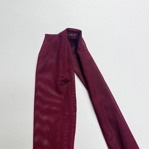 Detailed macro view of the wine red mesh fabric with a semi-transparent texture for dresses