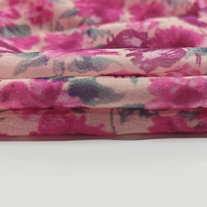 Close-up detail of soft pink floral print fabric with lightweight summer dress texture