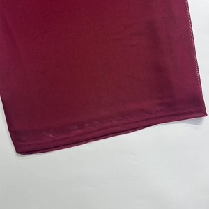 Detailed close-up of burgundy red fabric stitching and twill texture on a slim mini dress