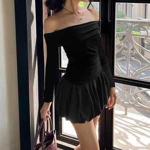 Detail of off-shoulder black dress showing pleated bodice and puffy skirt textures