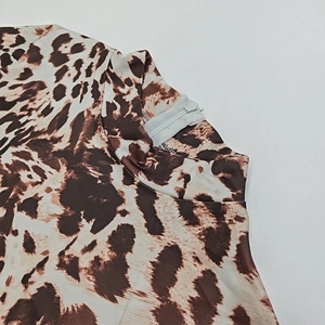 Detail of invisible back zipper on leopard print bodysuit with high collar design