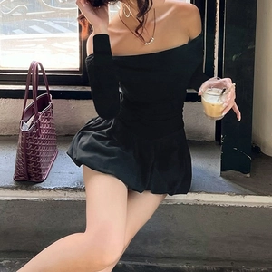 Detail of elegant black off-shoulder puff dress with long sleeves and bubble hem design