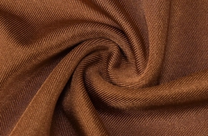 Gros plan du tissu en maille côtelée bronze avec éclat soyeux et texture drapée