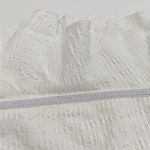 Détail du tissu blanc plissé haute densité avec couture élastique sur une robe