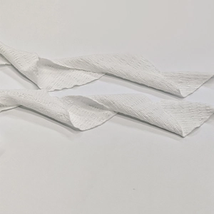 Gros plan détaillé montrant la texture froncée et le tissu plissé du ruban de robe blanc