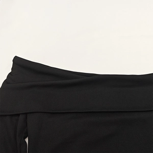 Detail view of the ribbed knit texture and elegant off-the-shoulder collar on a black top