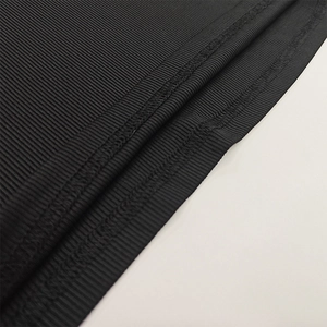 Macro shot of black ribbed knit fabric and reinforced seam stitching on women's dress