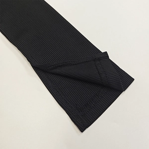 Detailed view of black ribbed knit fabric featuring a side slit and precise stitching