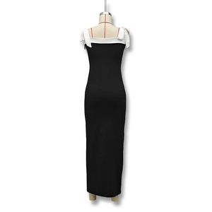 Detail showing elegant white bow tie shoulder straps and an open back on the slim black dress