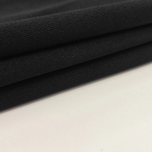 Dettaglio del tessuto nero a maglia ad alta densità con drappeggio elegante e trama fine
