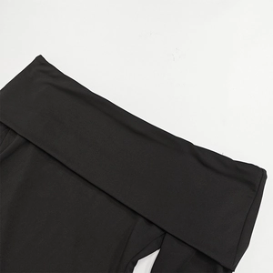 Detail of off-shoulder neckline and stitched fabric on elegant black mini dress