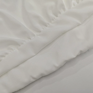 Detailed macro view of white pleated satin fabric texture on off-shoulder mini dress