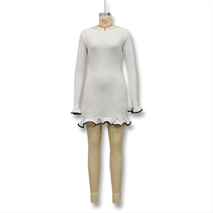 Détail de la robe courte en tricot blanc avec bordure volantée et liseré noir contrasté