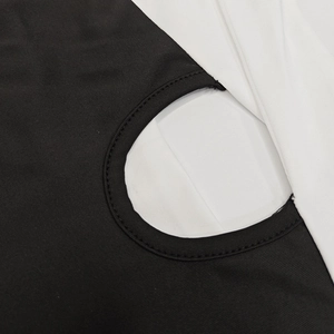 Detail shot of the contrast color stitching and circular cutout on the black and white dress