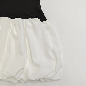 Detail of contrast stitching and ruffled satin hem on off-the-shoulder mini dress