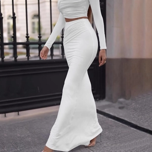 Detail of white long sleeve crop top and high waist side-ruched skirt set on a model