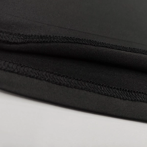 Detailed close-up showing high-quality double-stitch hem on black knitted fabric