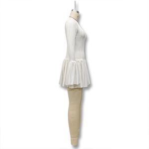 Détail d'une robe plissée blanche avec manches évasées et ourlet à volants sur mannequin