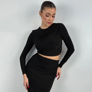 Women's 2-piece black slim fit set featuring long sleeve crop top and pleated skirt