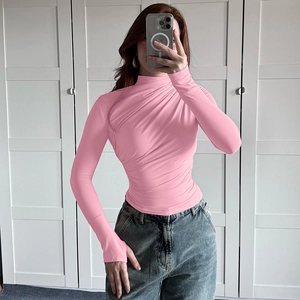 Detail showing the pleated texture and ruched design of the pink turtle neck slim top