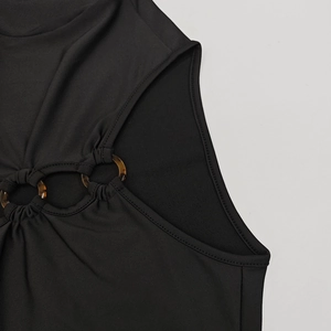 Détail du haut en tricot noir avec découpe froncée et anneaux en résine élégants