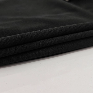 Gros plan sur la texture du tricot noir montrant les détails de tissage et la douceur