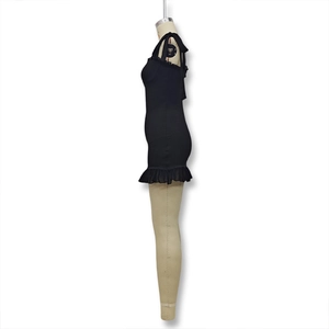 Detail of black mini dress featuring bow shoulder straps and ruffled lace trim details