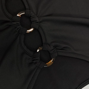 Détail de la robe noire découpée avec anneaux en écaille et coutures précises