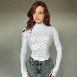 Close-up of white long sleeve turtleneck top featuring elegant ruched front details
